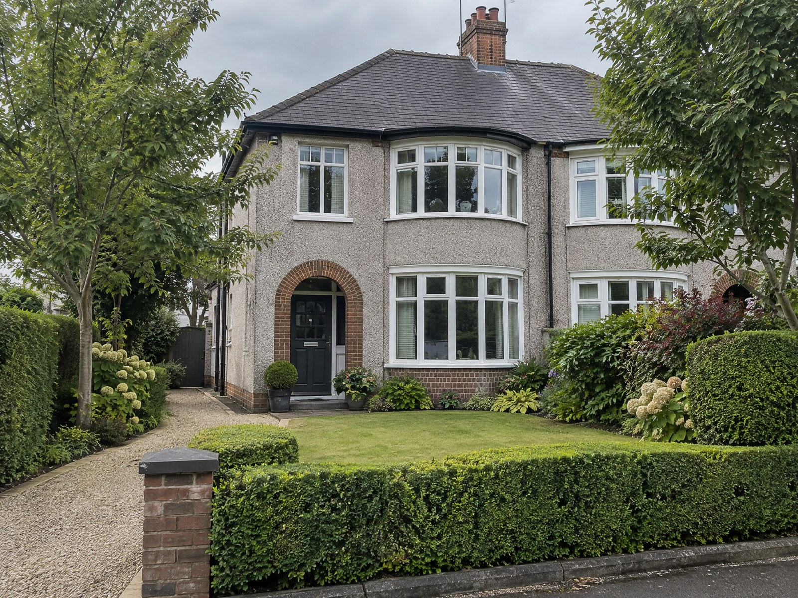 Trimmed hedges and trees at a Northern Ireland semi-detached house